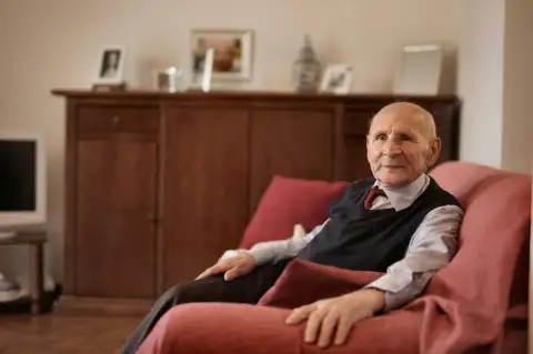 Elderly resident relaxing in his armchair while receiving home care support in Warwickshire